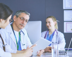 Serious medical team using a laptop in a bright office