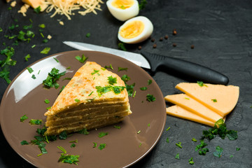 cheese tortilla with greens and cheese is cut into triangles on a dark background . ingredients grated cheese, eggs, gluten-free chickpea flour. vegetarian Breakfast. the view from the top