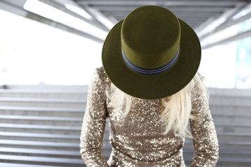 Faceless blonde in  green flet canotier hat and golden dress symmetrically stands under bridge in Paris. Street fashion © Oksana