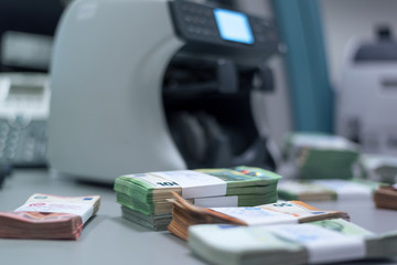 Bundles of banknotes divided into groups with currency straps placed on the electronic counting...