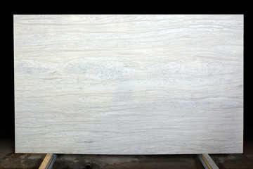 A large slab of white marble with stripes and dots called Nestos Beige