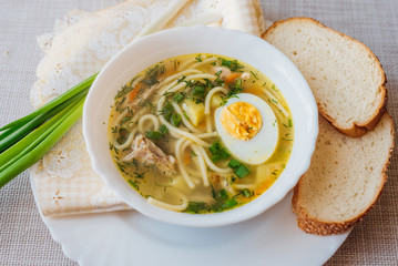Homemade chicken soup with homemade egg noodles, horizontal, copy space