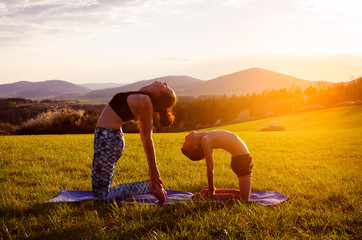 Mother and son practicing yoga in nature