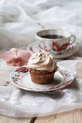 cupcake with spring flower  on plate and wooden background