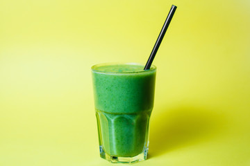 glass of smoothie with straw on green studio background best