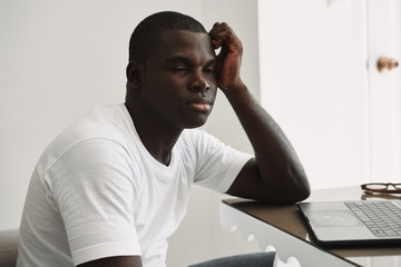 man of african appearance in front of a laptop