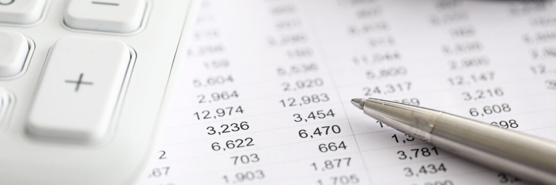 Silver pen report with numbers next to calculator