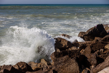 ocean waves are hitting the rocks
