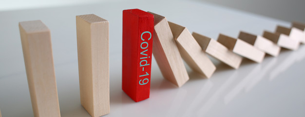 Red wooden block with Covid19 sign close-up background. Coronavirus covid 19 stop concept.