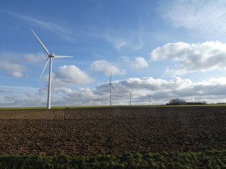 Row of five wind turbines in a field in France, Europe