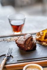 Beef steak with sauce and potato and shot of whisky