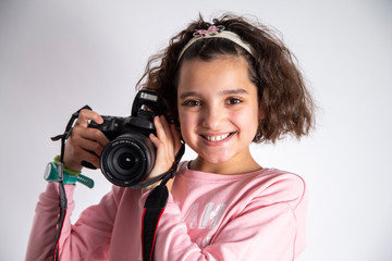 Girl holding a camera with a smile.