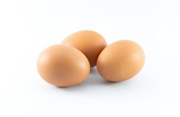 Close up of three organic raw brown chicken eggs isolated with white background