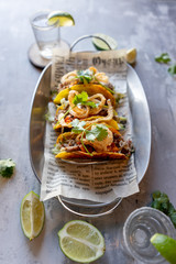 Mexican meat tacos with tequila shots on stone background