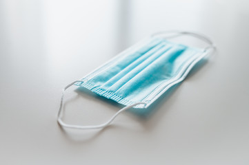 Used protective mask on white table. Hospital background. Novel coronavirus 2019 COVID-19 theme. Coronavirus wallpaper on tablet. Coronavirus protection.