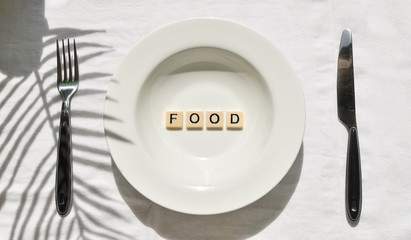 Food shortage words and forks and knives on plates with a food shortage concept.