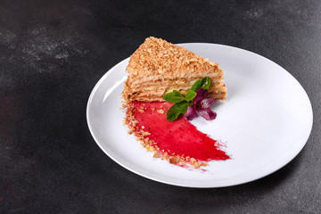 Fresh delicious cake napoleon with cream on a dark background
