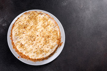 Fresh delicious carrot cake with cream on a dark background