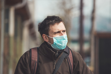 Flue and corona safety concept. Man wearing face mask to protect himself, outdoors