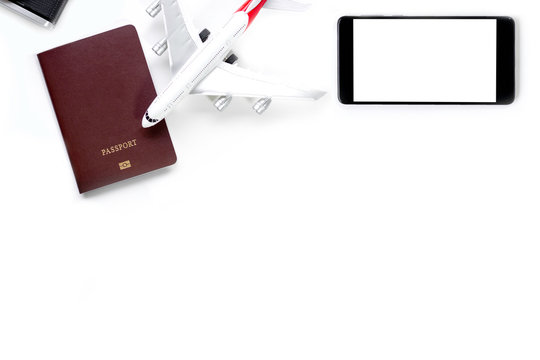 Mockup image of mobile smart phone with blank white screen, passport, camera and airplane model isolated on white background. Technology and Travel concept.  Clipping path. Top view. Flat lay.
