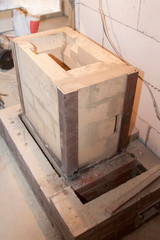 Sauna stove that is being built from fire resistant material in undeveloped interior laid out of foam blocks in country house under construction