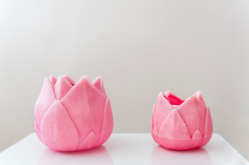 Two pink flower shaped candles with white background. Zen and minimalist background with pastel tones. Space for text