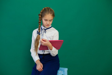 girl with an internet tablet in a lesson at the board at school