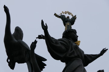 gray metal or stone statue of women with golden wreath