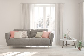 White living room with sofa and winter landscape in window. Scandinavian interior design. 3D illustration