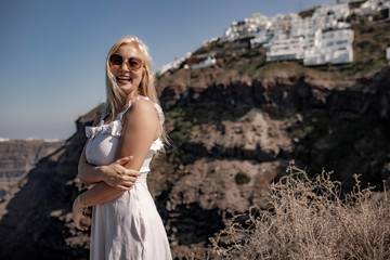 Fototapeta na wymiar Girl in a white dress on a background of mountains and sea