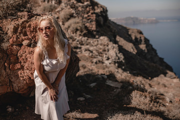 Fototapeta na wymiar Girl in a white dress on a background of mountains and sea