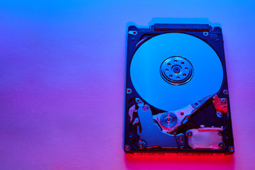 Disassembled hard drive from the computer, hdd with neon light. Opened hard drive Part of computer...
