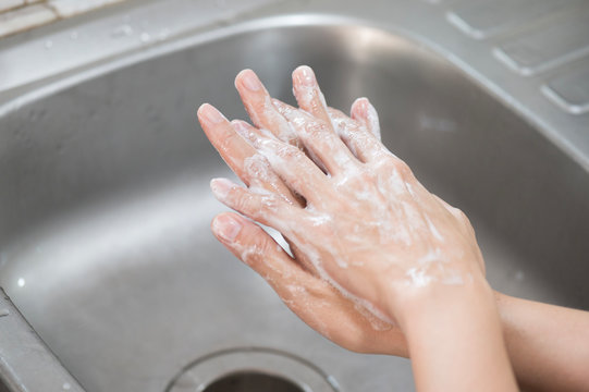 Close up woman hand washing under running water in the kitchen.Hygiene and cleaning Hands.Image hand washing step concept.