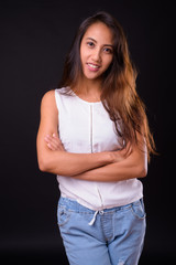 Young beautiful Asian woman against black background