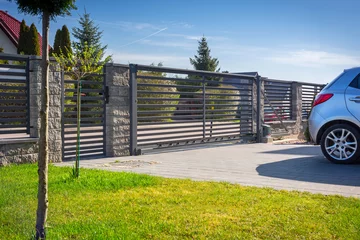 Fotobehang Stone fence and entrance gate with remote control © Patryk Kosmider