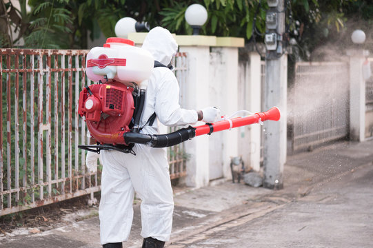 A Man Wearing Personal Protective Equipment(PPE) Sraying Of Disinfectants On A Public Place In The Vilage As A Prevention Against COVID-19. State Of Emergency Over Coronavirus.