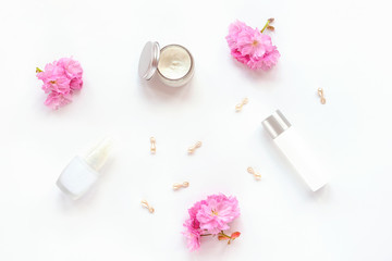 Facial and body care cosmetics bottles on isolated white background. Serun, moisturizer, cream jar and beauty capsules. Top view, flat lay
