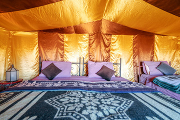 Beds inside elegant tent set on Sahara desert, Morocco