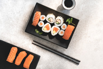 Japanese sushi food. Maki and  rolls with spicy tuna, salmon, tofy and  avocado. Top view of assorted sushi, uramaki, hosomaki and nigiri on the stone natural background