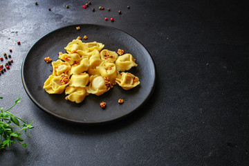 tortellini, pasta with filling (ravioli or dumplings)
second course
Menu concept. food background. top view copy space for text