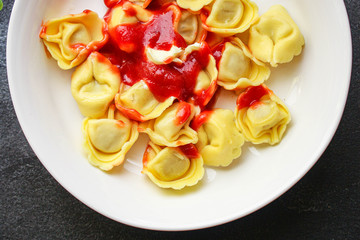 tortellini, pasta with filling (ravioli or dumplings)
second course
Menu concept. food background. top view copy space for text