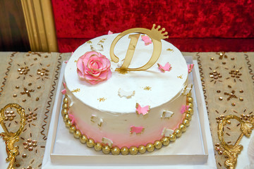 One age D letter gold color. Cake with Number 1 Candle . White cake. Pink flowers.