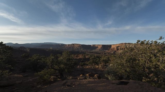 A wide sunset timelapse of distant red cliffs in Capitol Reef National Park lighting up in stunning red colour as the sun moves towards the horizon.