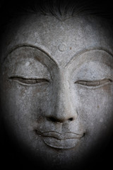 Mystical Buddha statue's face, face of ancient stone Buddha statue