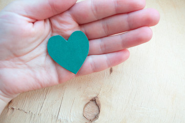 Fototapeta premium Hand holds a green heart. Life style. Healthy eating. Love of nature. Jealous heart. Relationship problems. Hope. St.Patrick 's Day.