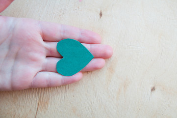 Hand holds a green heart. Life style. Healthy eating. Love of nature. Jealous heart. Relationship problems. Hope. St.Patrick 's Day.