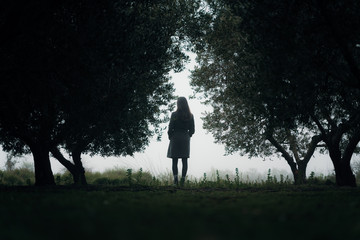 Woman walking through forest in the fog