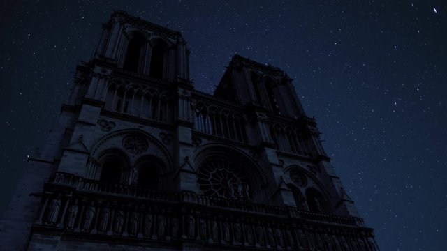 Stars and night sky moving over Notre-Dame Cathedral in Paris, France. Cinemagraph timelapse style