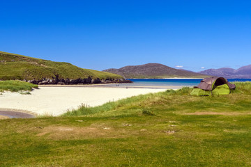 Fototapeta na wymiar Isle of Harris, Outer Hebrides, Scotland / UK - August 27, 2014: A lonely camping tent in the white sand beach of Traigh Niosaboist
