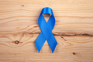 Blue ribbon as a symbol of prostate cancer awareness. blue ribbon on a wooden background. close up